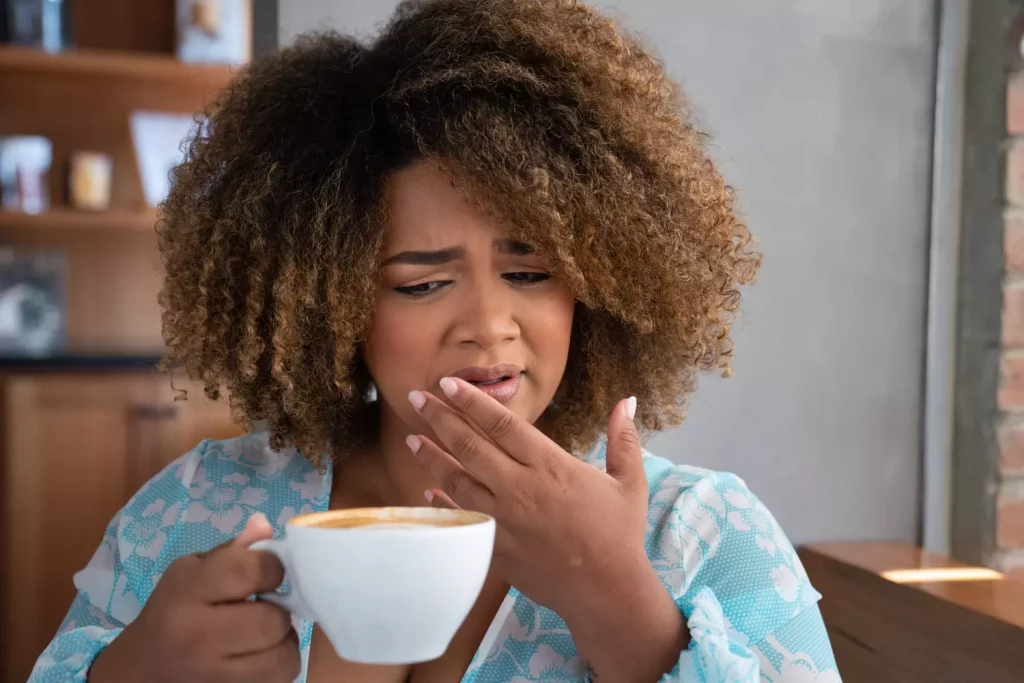 Une dame qui vraisemblablement n'apprécie pas son café car trop amer.