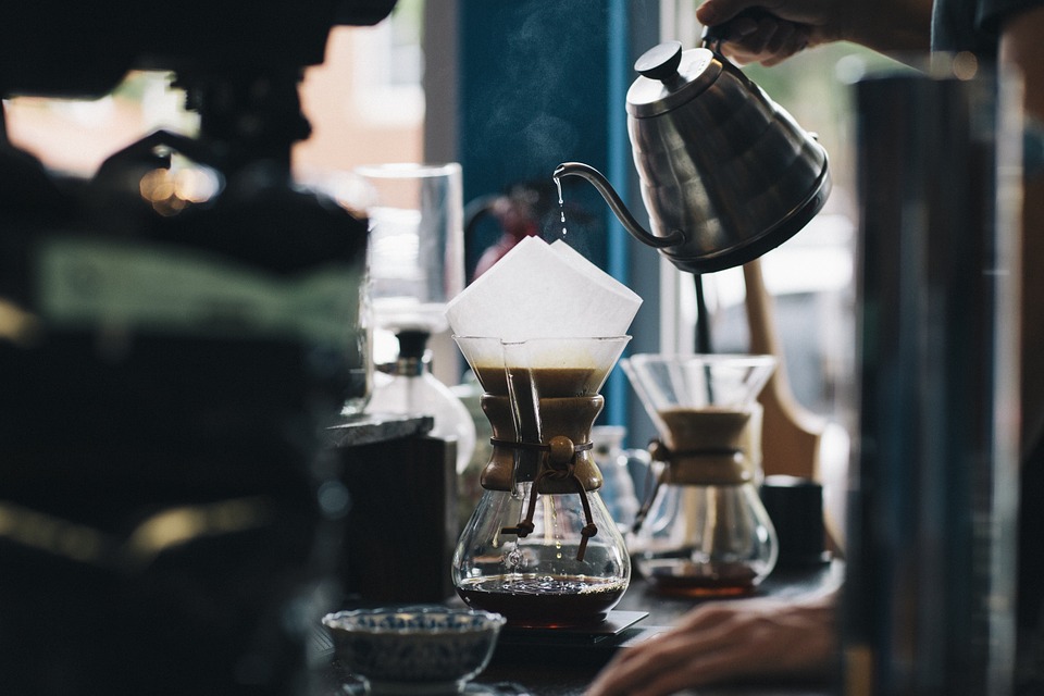 Cafetière d'eau chaude versée dans une filtre a café. 