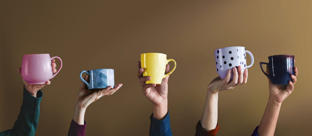 5 mains en l'air avec des tasses différentes pour déguster du café 