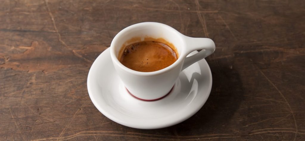 Une tasse d'espresso frais sur une soucoupe. Un des types de café les plus fréquent.