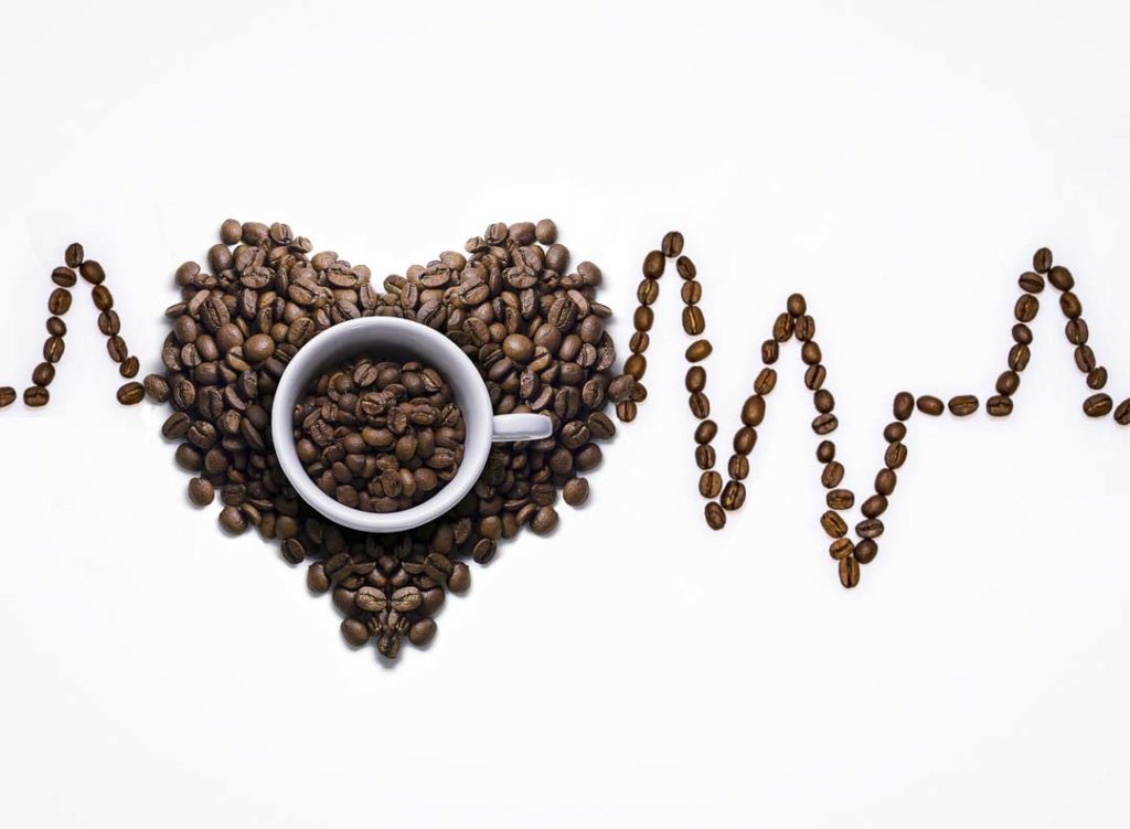 Des grains de café qui forment un coeur et une ligne cardiaque.