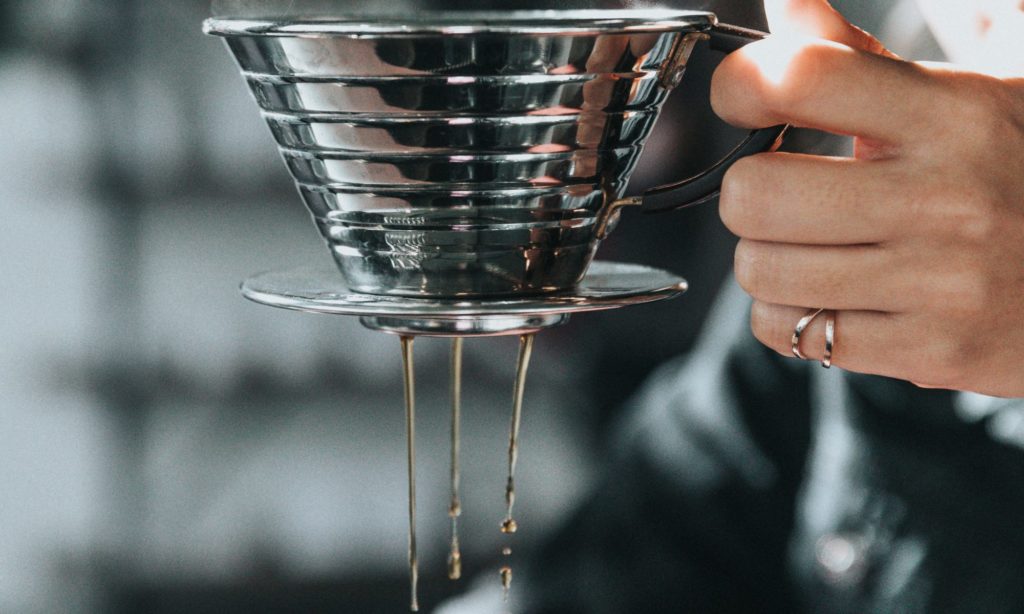 Du café coule depuis une cafetière Kalita Wave en alluminium.