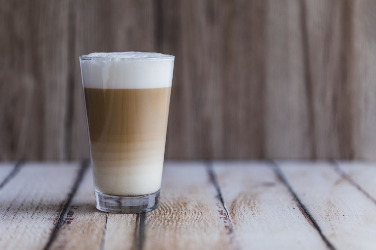 Café latte macchiato avec une vue claire sur les différents niveaux dans le verre transparent